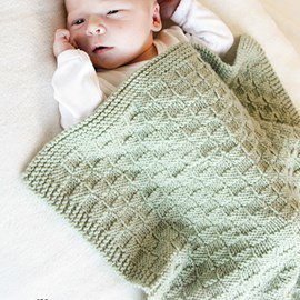 Drops DROPS breipatroon little things, babydeken is textuurpatroon en ribbelsteek. Deze deken voor ledikant of wieg is gemaakt van het garen DROPS merino extra fine.
