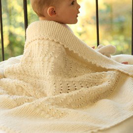 Drops Gebreide DROPS deken met een golvenpatroon van Merino Extra Fine.&nbsp;Een zachte deken voor een tere babyhuid. Afmeting: ongeveer 65 x 80 cm 